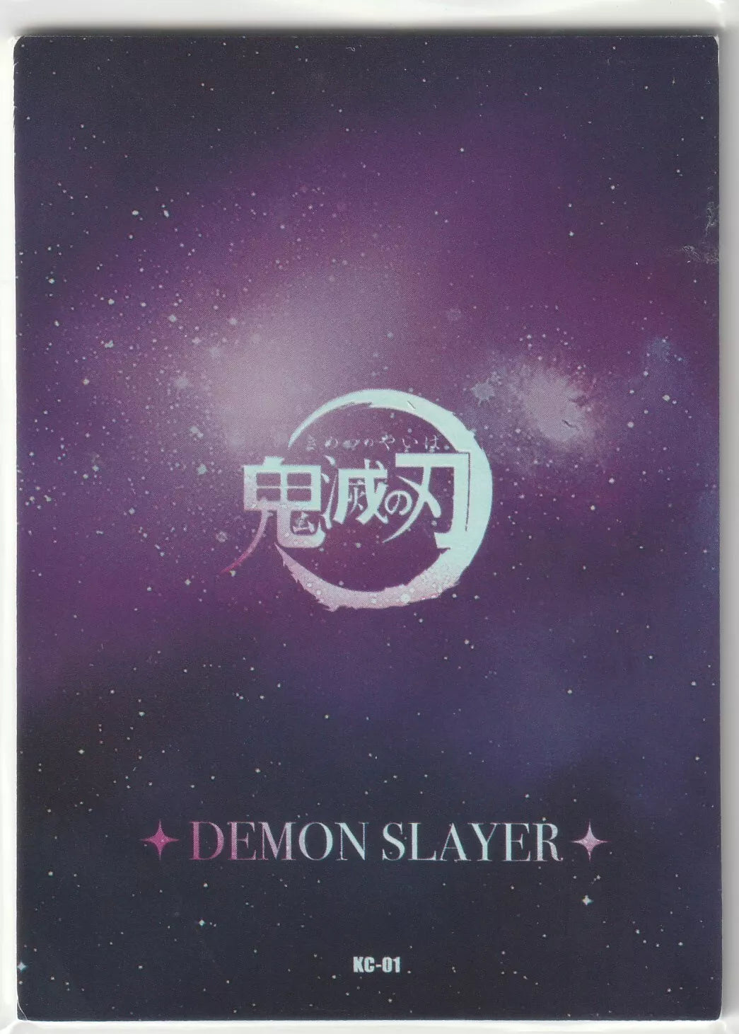 The back of the Demon Slayer KC-01 card featuring a cosmic purple background with stars, Kimetsu no Yaiba logo, and card number "KC-01."
