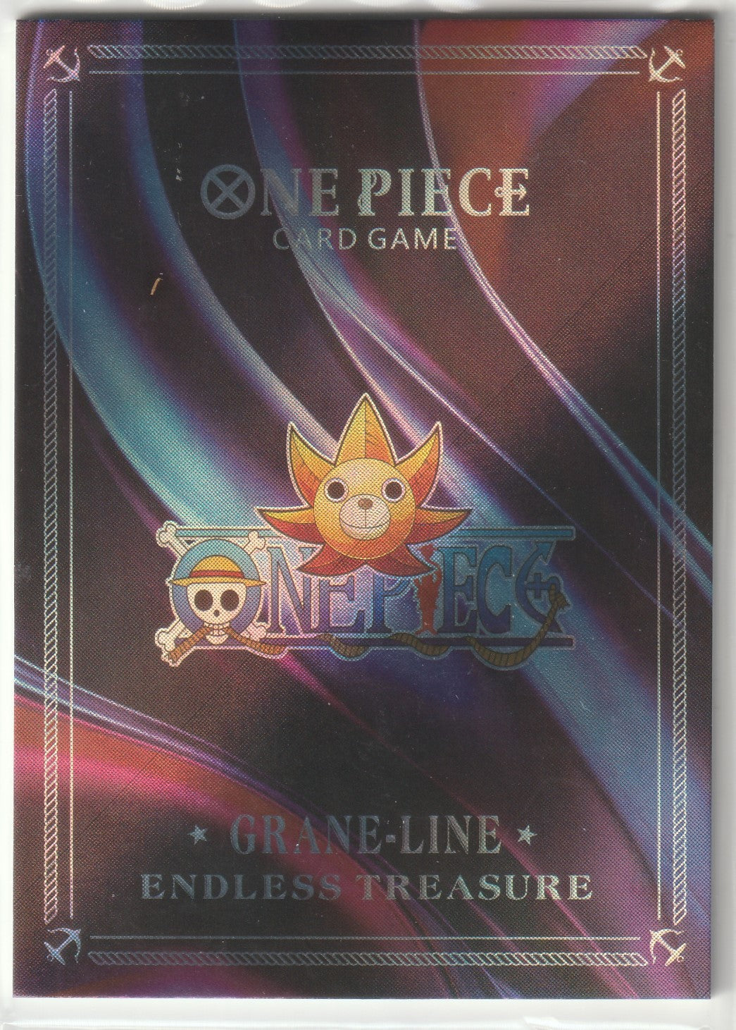 Holographic back of One Piece Card Game card with Grand Line Endless Treasure design and Thousand Sunny emblem.