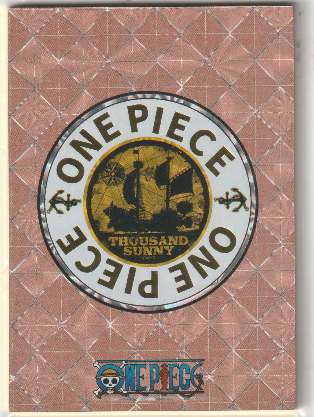 Back of One Piece STR collectible card featuring gold Thousand Sunny ship and One Piece logo with grid design.