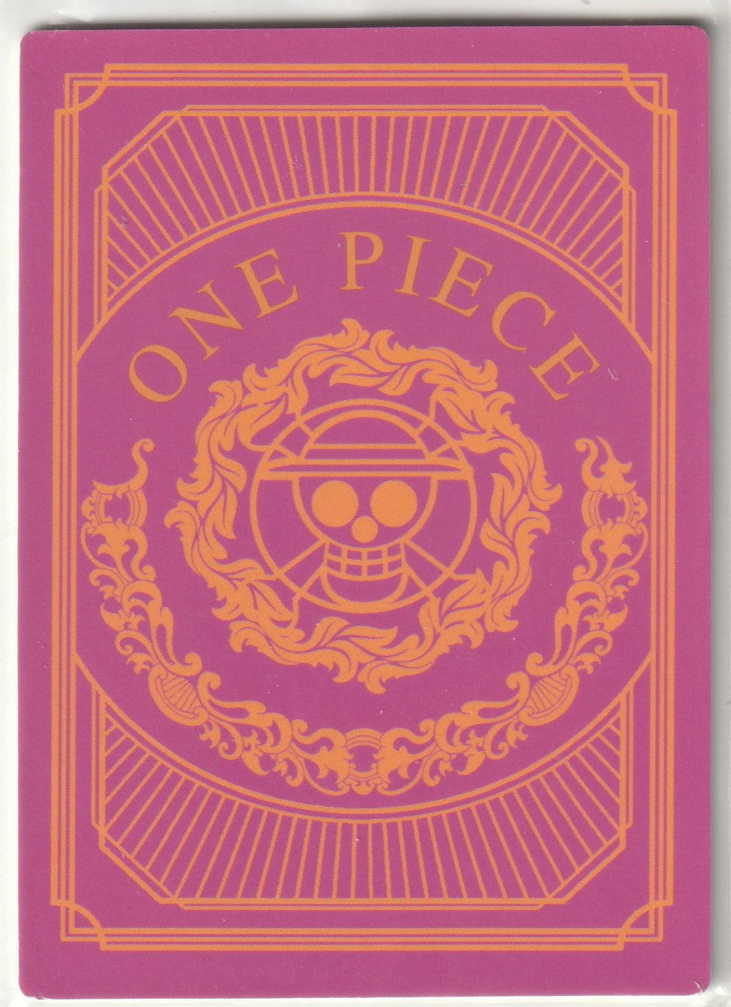 Back of One Piece collectible card with ornate orange Straw Hat Pirates logo on a magenta background.