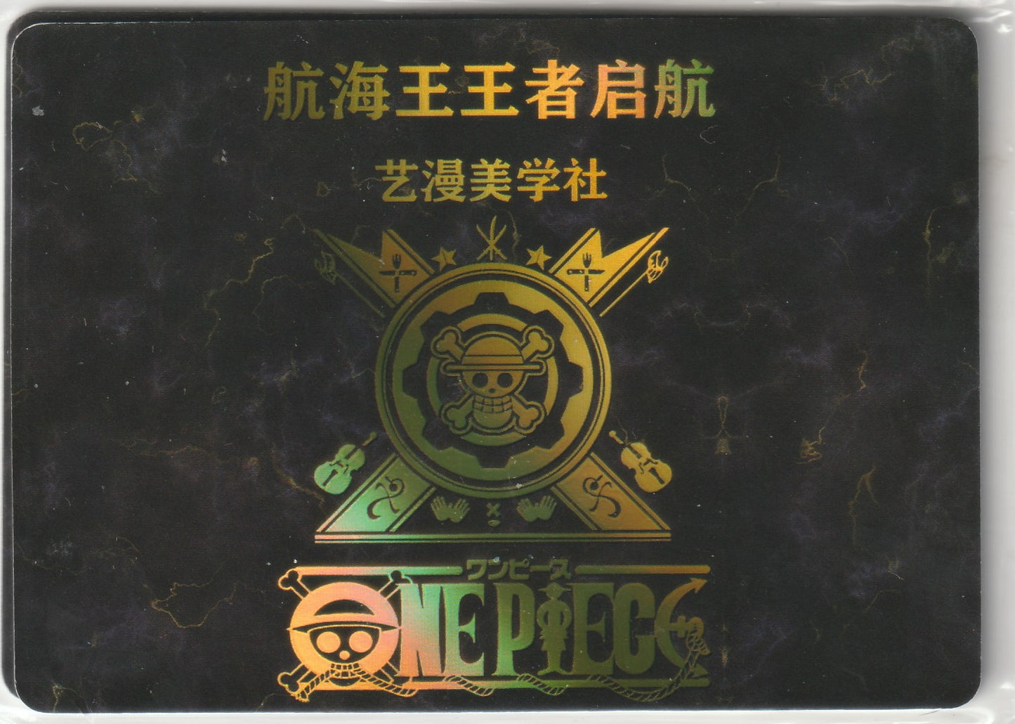 Gold foil One Piece emblem on a dark marbled background with intricate utensil and instrument designs.