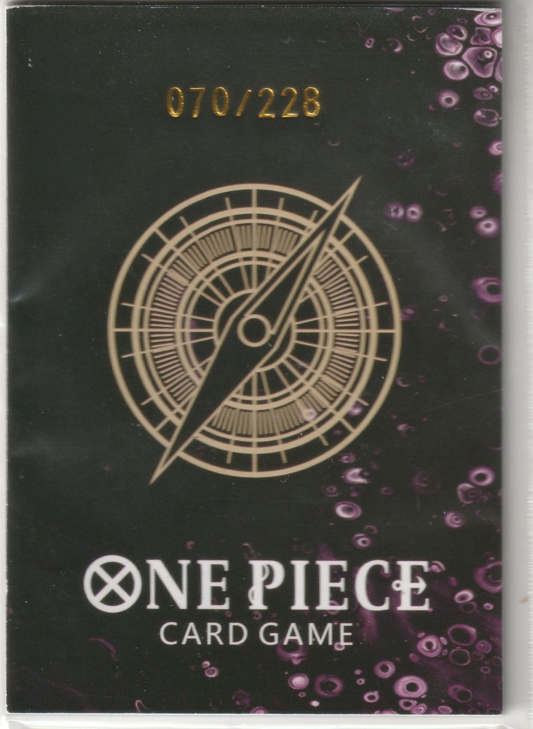 Compass design in gold with the One Piece Card Game logo and "070/228" limited-edition numbering on a dark background.