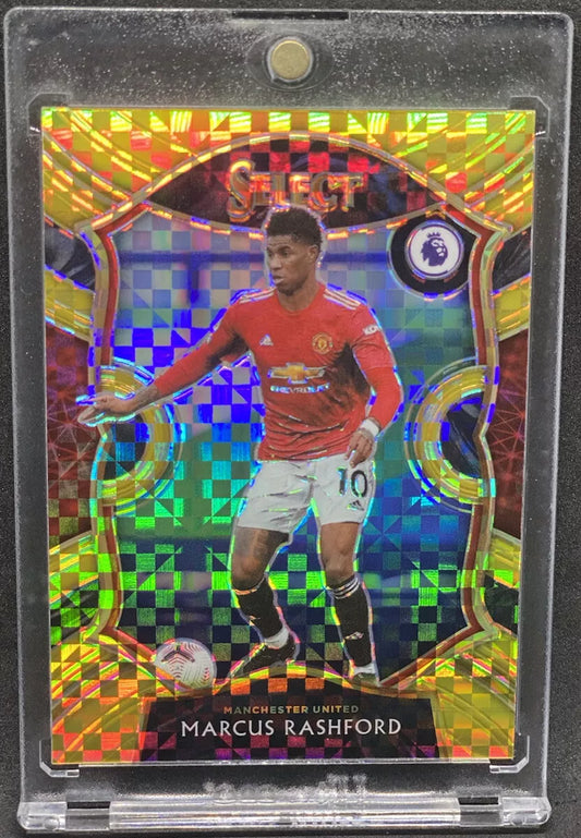 Marcus Rashford in Manchester United red kit, Topps Select gold power prizm card design with colorful checkered background and Premier League logo.
