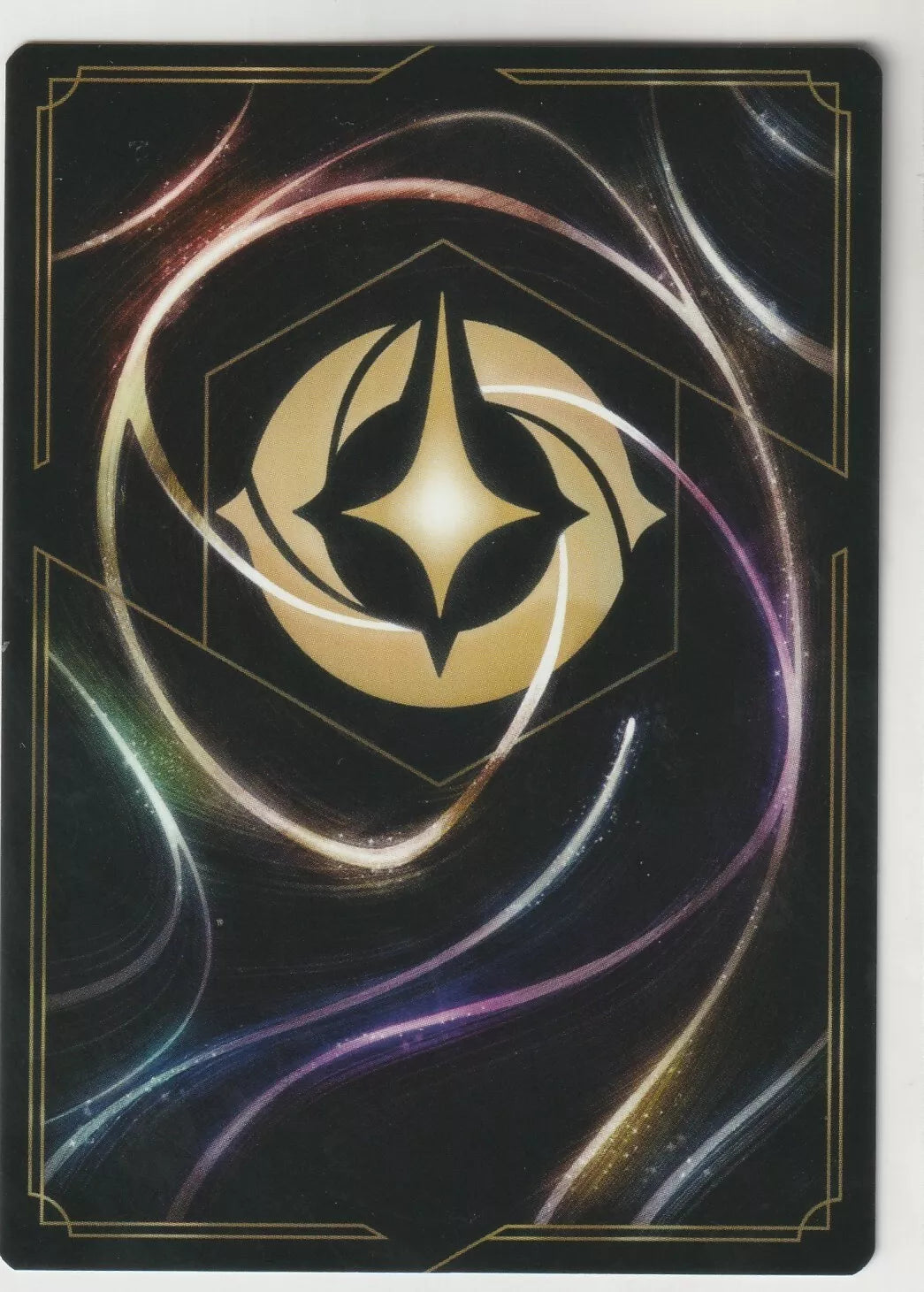 Back view of Disney Lorcana card featuring a swirling cosmic design with a central gold emblem