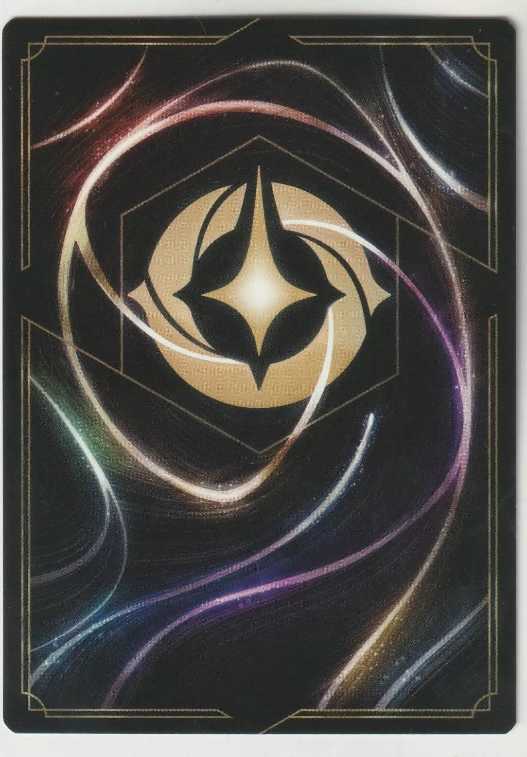 The back of the Lorcana card shows a gold star-like symbol in the center, surrounded by colorful, swirling energy lines.