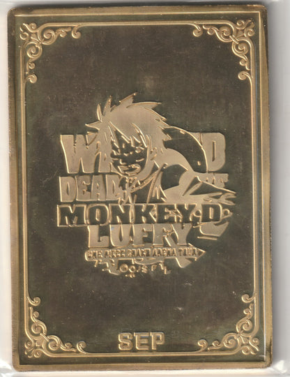 "Metallic gold card with Monkey D. Luffy's embossed 'Wanted' poster design and decorative borders."