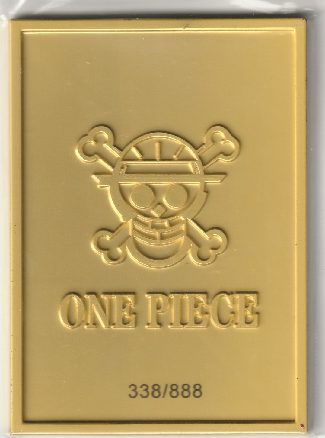 One Piece fully metal card back with an embossed Jolly Roger emblem, serial number 338/888, and a sleek minimalist design.