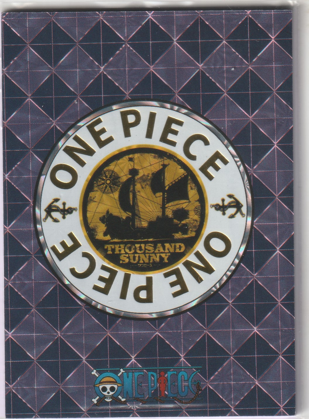 Gold and black Thousand Sunny emblem on a holographic grid background with 'One Piece' text around the circle.