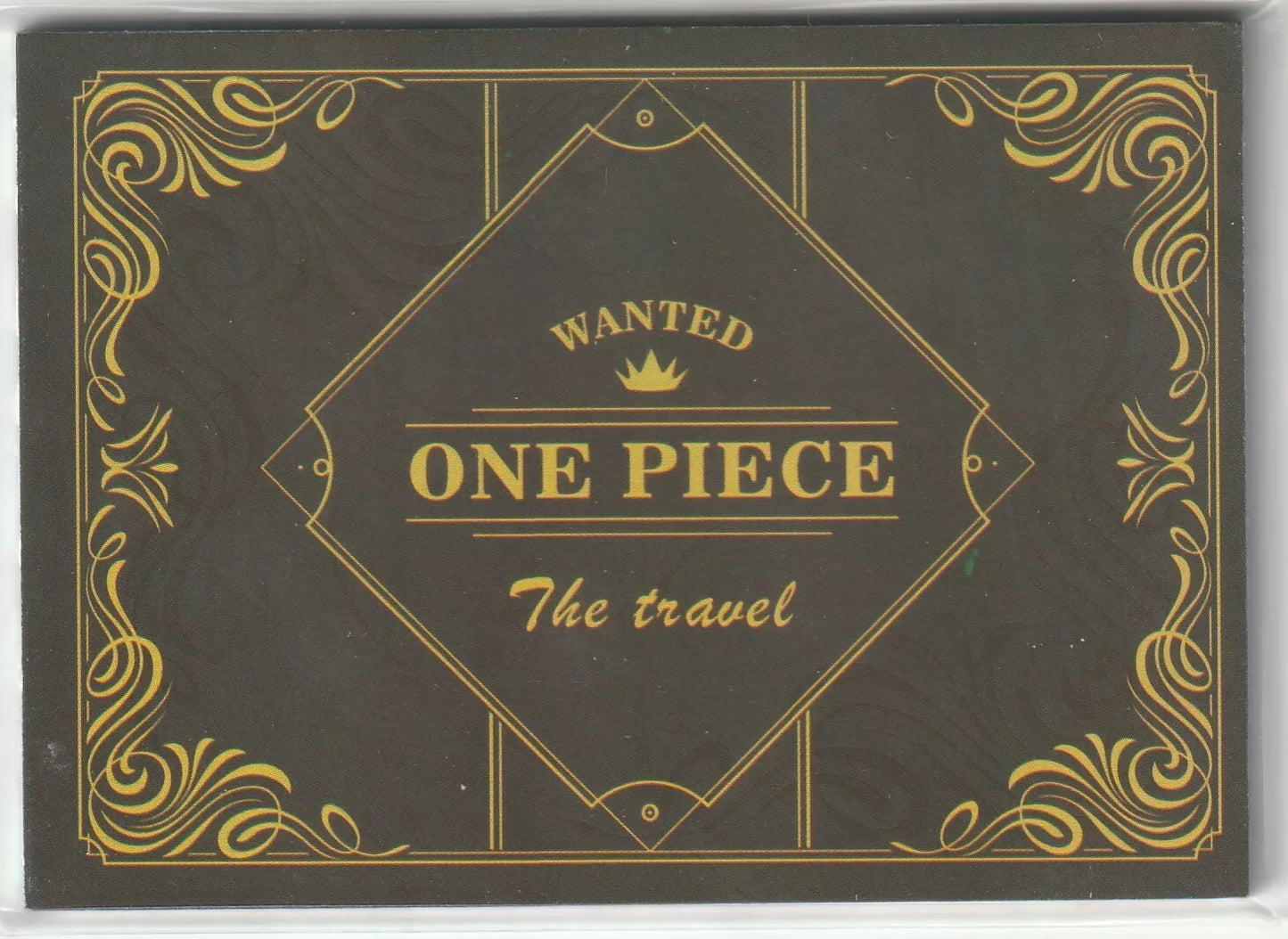 One Piece anime card back design with black background, golden ornate details, and the words 'WANTED ONE PIECE The travel' in a central diamond-shaped design.