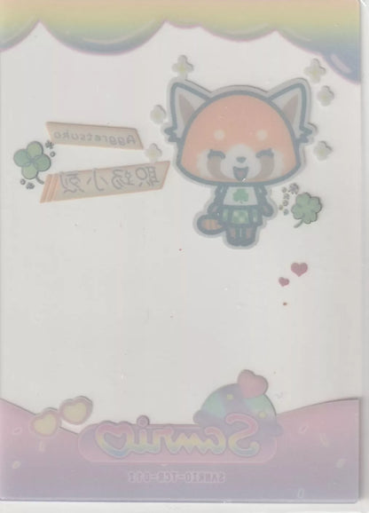 "Aggretsuko collectible card back with a reversed image of Aggretsuko, clovers, rainbow, and 'Sanrio' logo, slightly faded due to the card's transparent material."